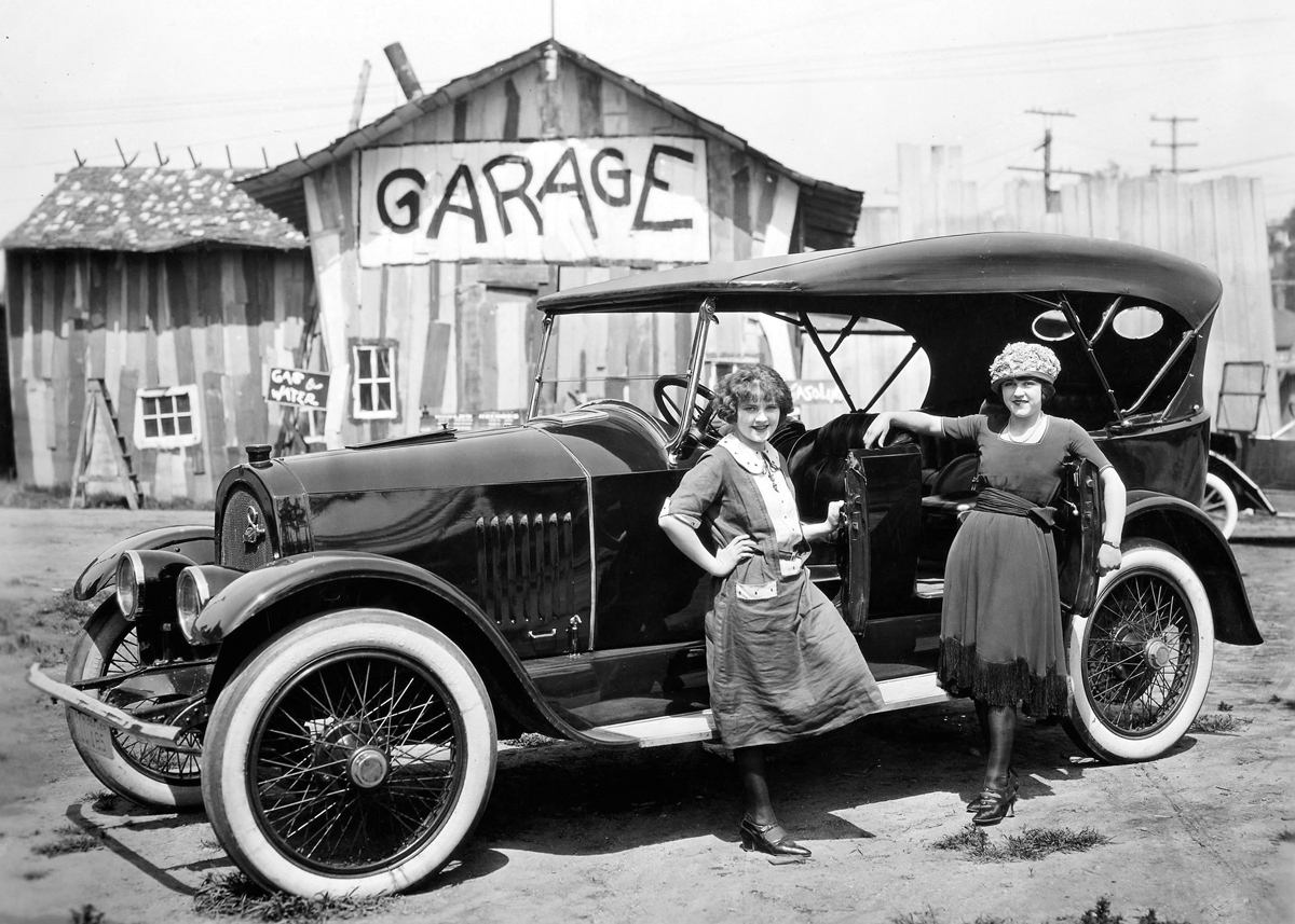 Two woman with car outside garage Two woman with car outside garage