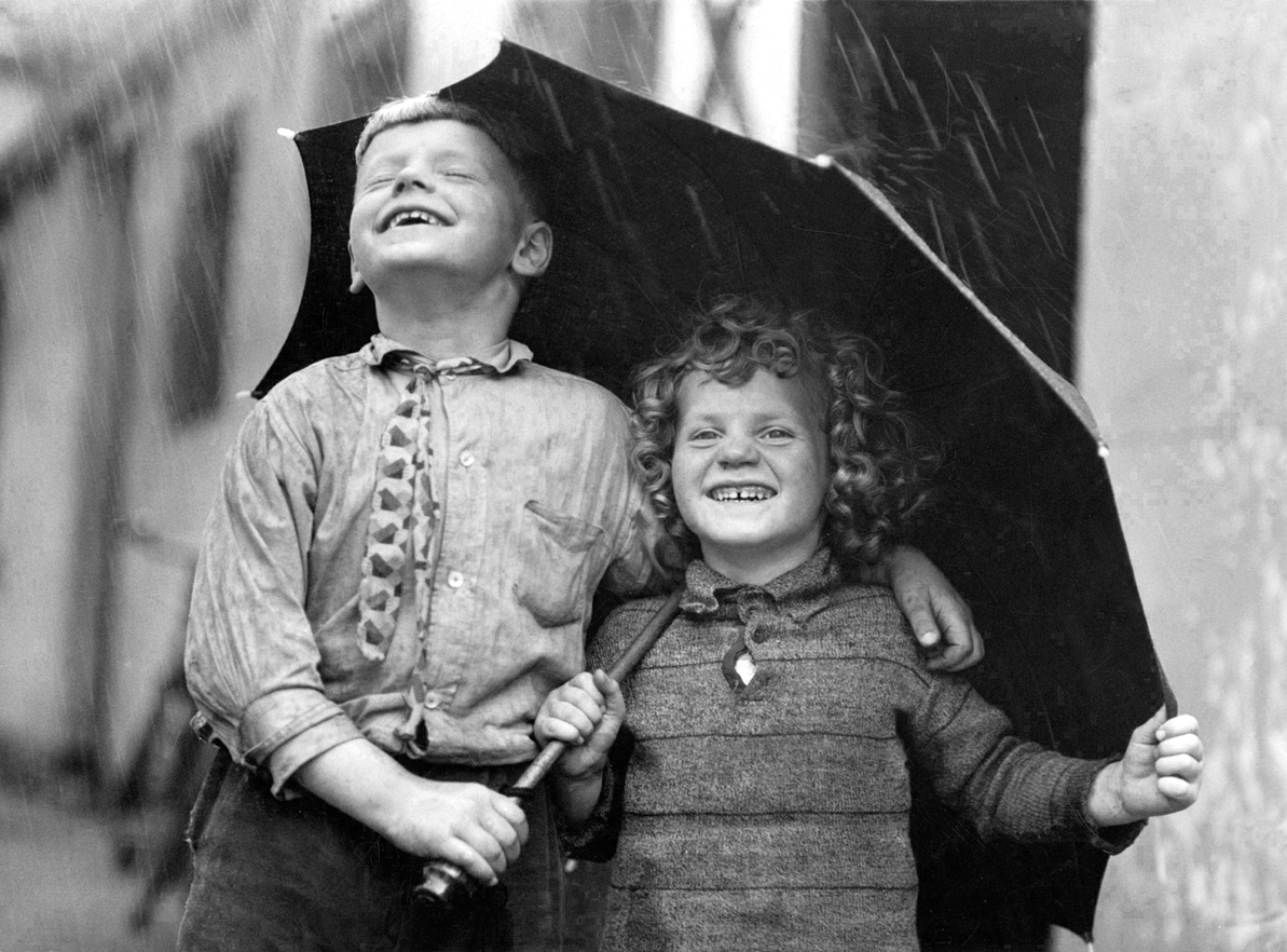 Children sharing an umbrella Children sharing an umbrella