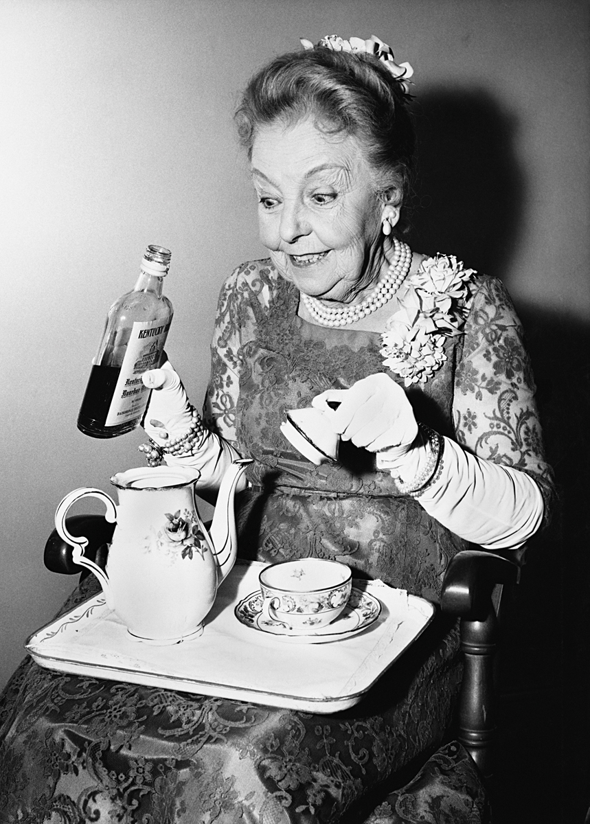 Lady adding gin to her tea Lady adding gin to her tea